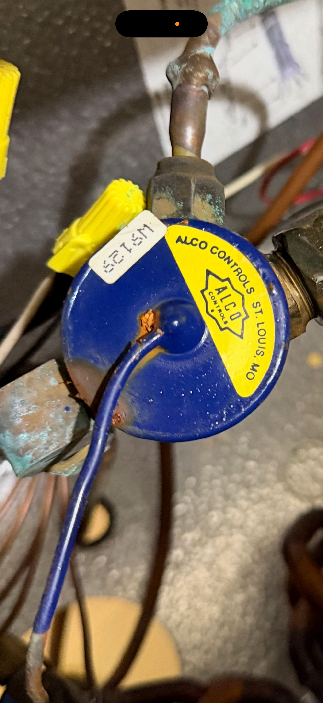 Refrigerant service gauge connected to HVAC piping